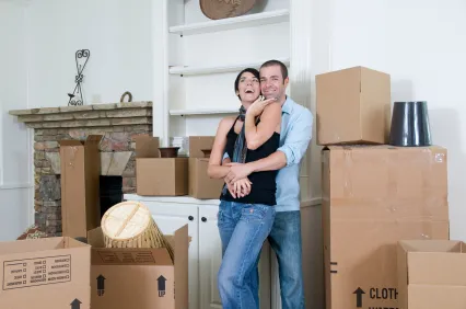 a couple standing in front of the moving boxes
