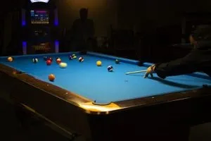 people play on the pool table while waiting for pool table movers to help them relocate their pool table 