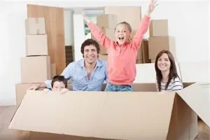 Parents with two children surrounded by boxes, smiling, satisfied with North Lauderdale Movers.