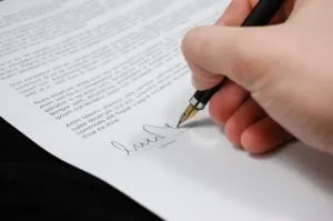A man signing a document, respecting the landlord rights in Florida.