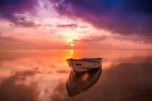 A small boat on the sea at sunset. 