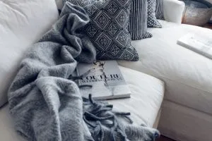 A couch with pillows and a blanket