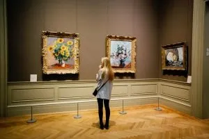 A woman looking at paintings.
