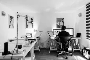 Transform your garage into a home office - man sitting at the desk top computer
