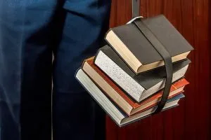 Man holding books with a belt