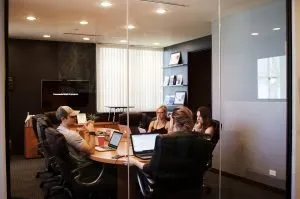 four people in a meeting - move your office to a bigger space