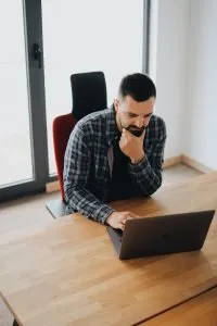 man thinking over laptop
