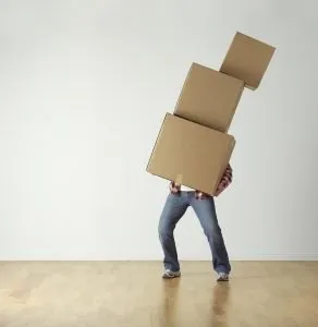 a man holding three boxes in an empty room