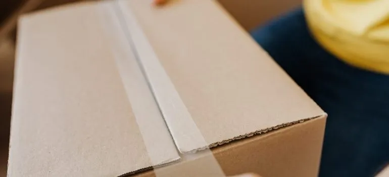 a man sealing the box with a tape
