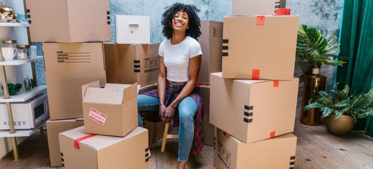 A girl sitting among packing boxes - local movers South Florida 