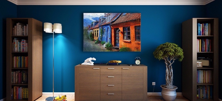 A room with blue walls, furniture and artwork