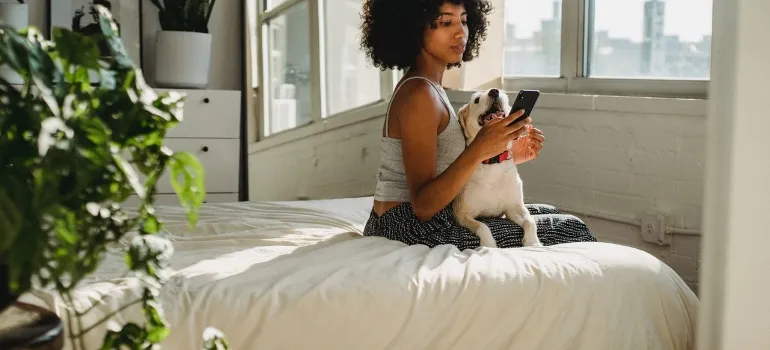 A woman with a phone and a dog 