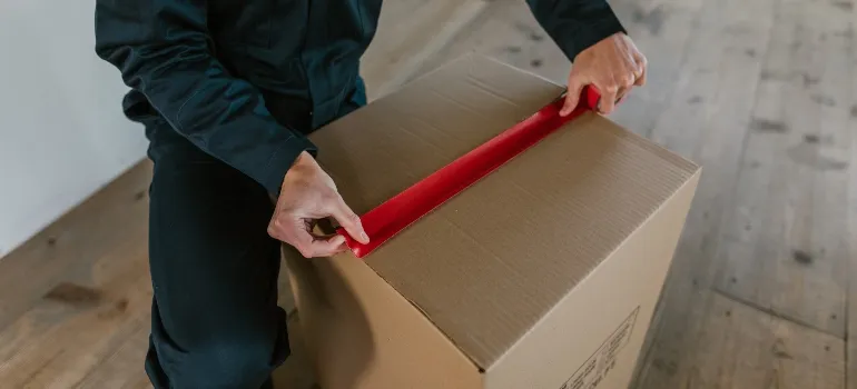a man sealing moving box