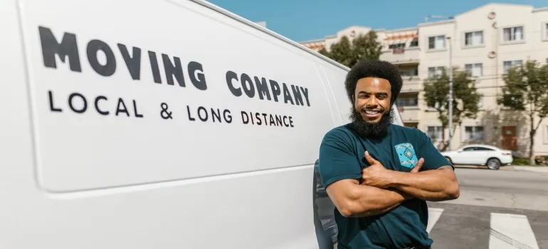 A worker is standing next to a moving van