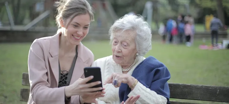 young girl showing an elderly woman about moving across Florida as a senior on the phone