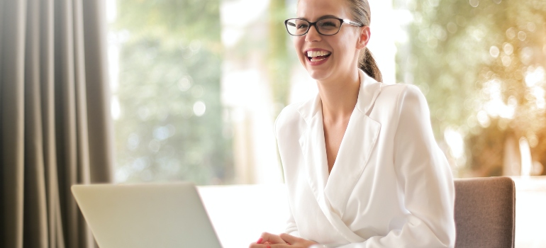 woman smiling and sitting with laptop