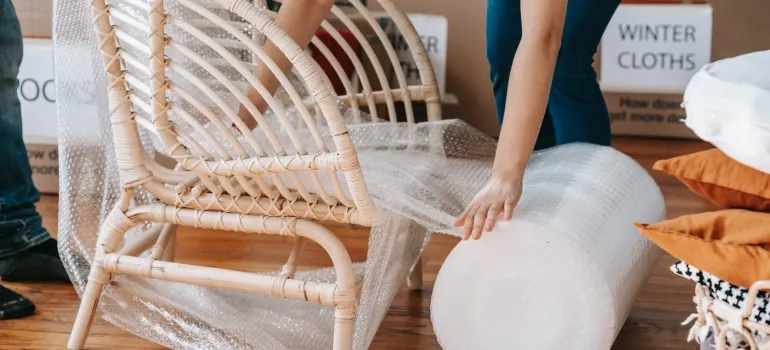 a person wrapping a chair in bubble wrap