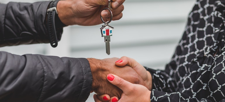 A person handing a key to another person