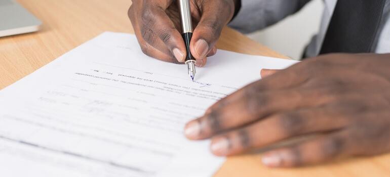 A person putting their signature on a document