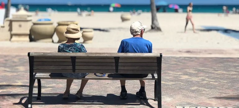 elderly couple sitting by the beach as retirement is common reason for moving from Miami to Pembroke Pines