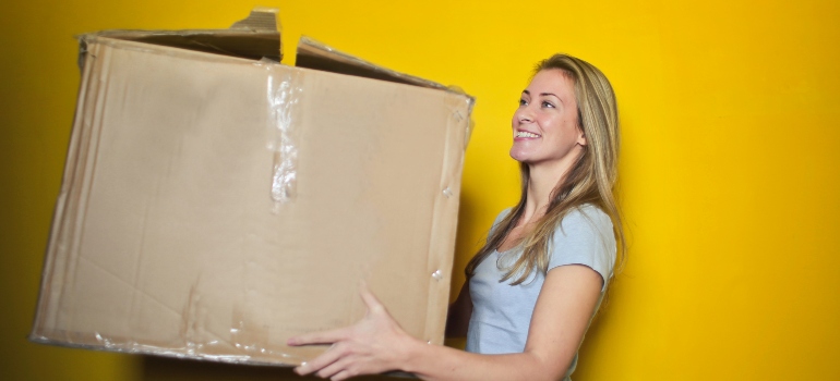 woman holding a big packing box
