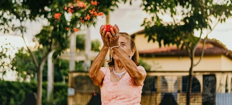 elderly woman throwing flowers after choosing between places in Florida for seniors