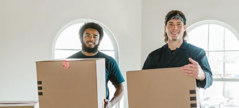 two movers holding boxes