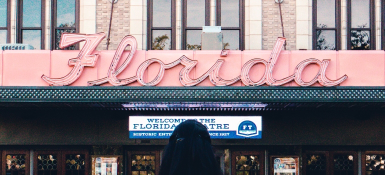 girl standing in front of the Florida sign representing where to move in Florida in 2023
