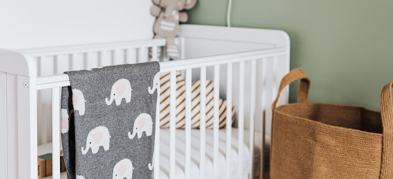 Baby blanket hanging on a white wooden crib