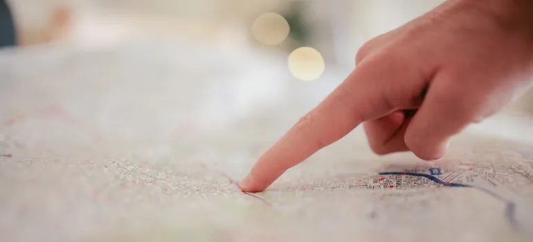 A finger pointing at a map.